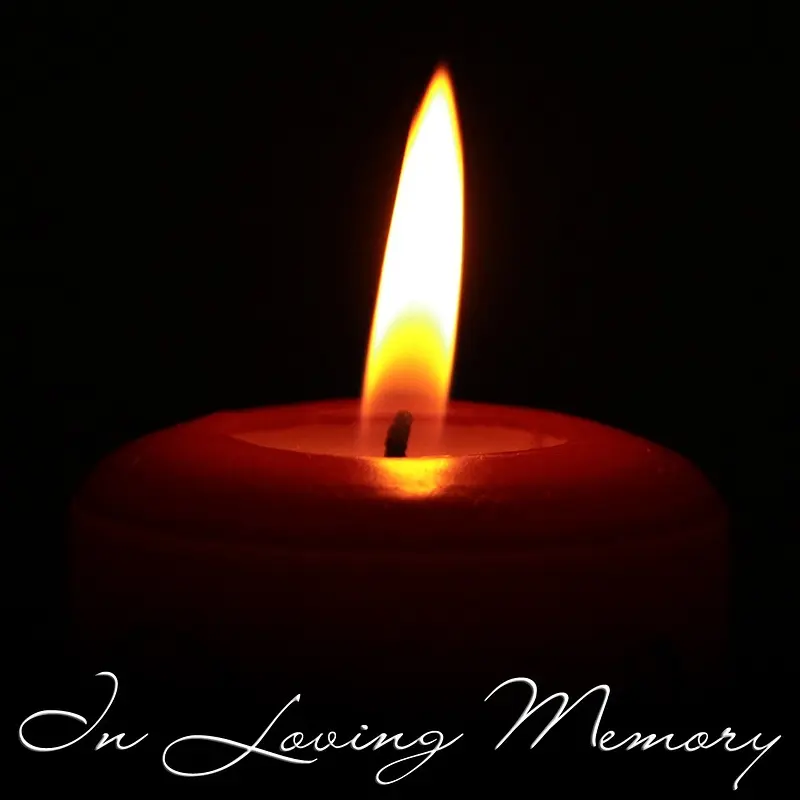 A candle with in loving memory written below