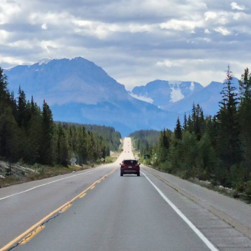 Mountains and road with car and trees. Marketing for Celebrant Life Journey Blog.